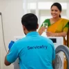 Technician repairing washing machine in nashik at home and customer offering water