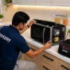 Microwave oven repair technician repairing a microwave oven at customer home.