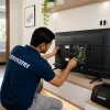 LED TV repair technician repairing a smart television at customer home.